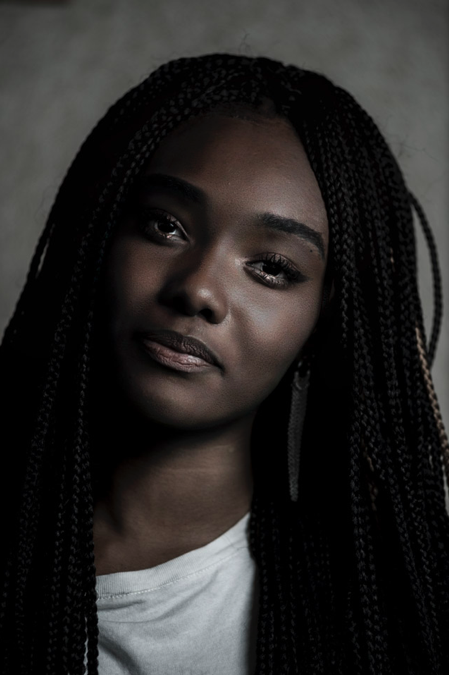 Portrait d'une jeune femme avec des tresses africaines prise en studio par Margo Production